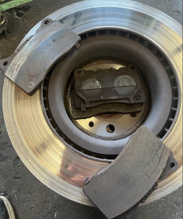 A worn brake rotor with its brake pads